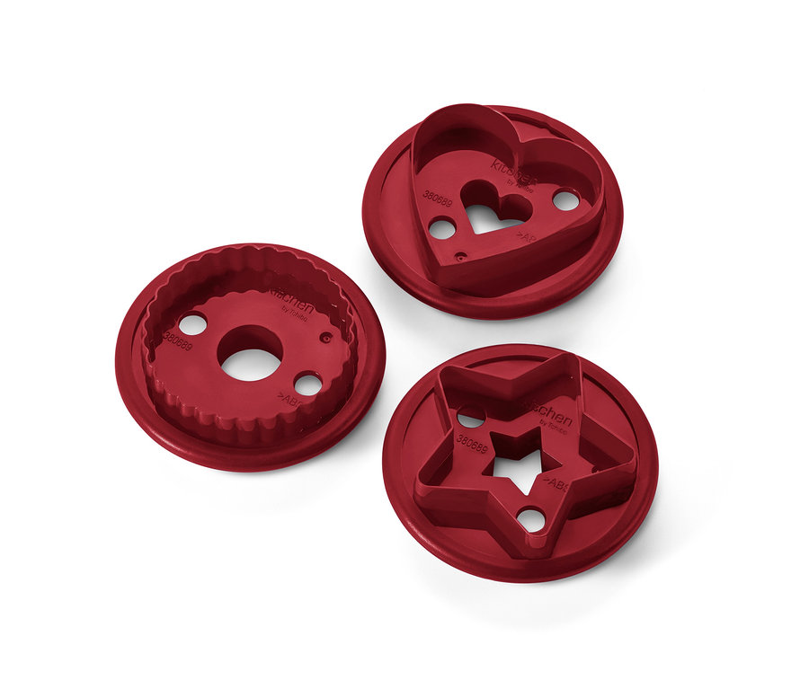 Tři červené vykrajovátka na linecké cukroví ve tvaru kruhu, srdce a hvězdy.