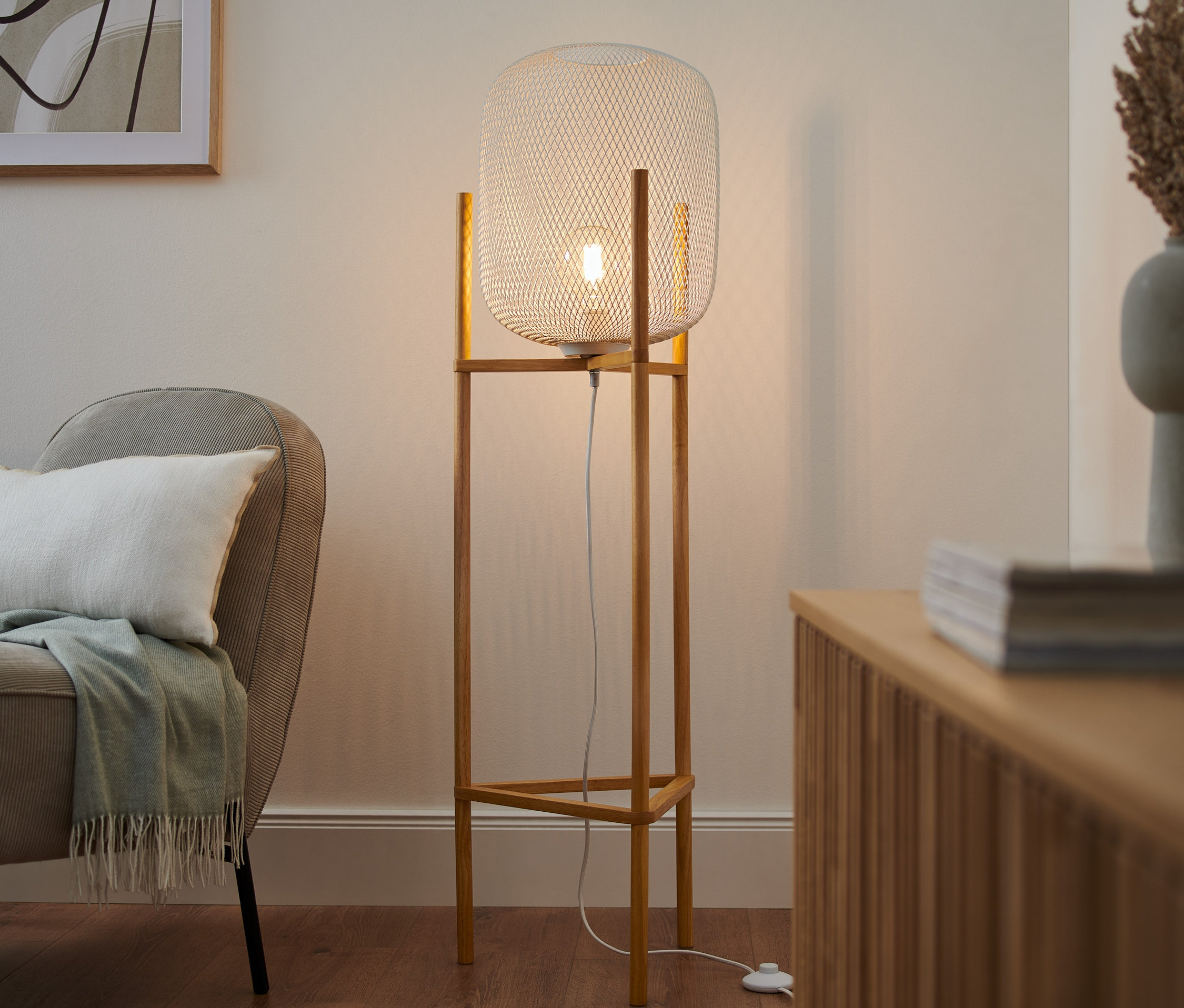 V obývacím pokoji stojí trojnohá stojací lampa.