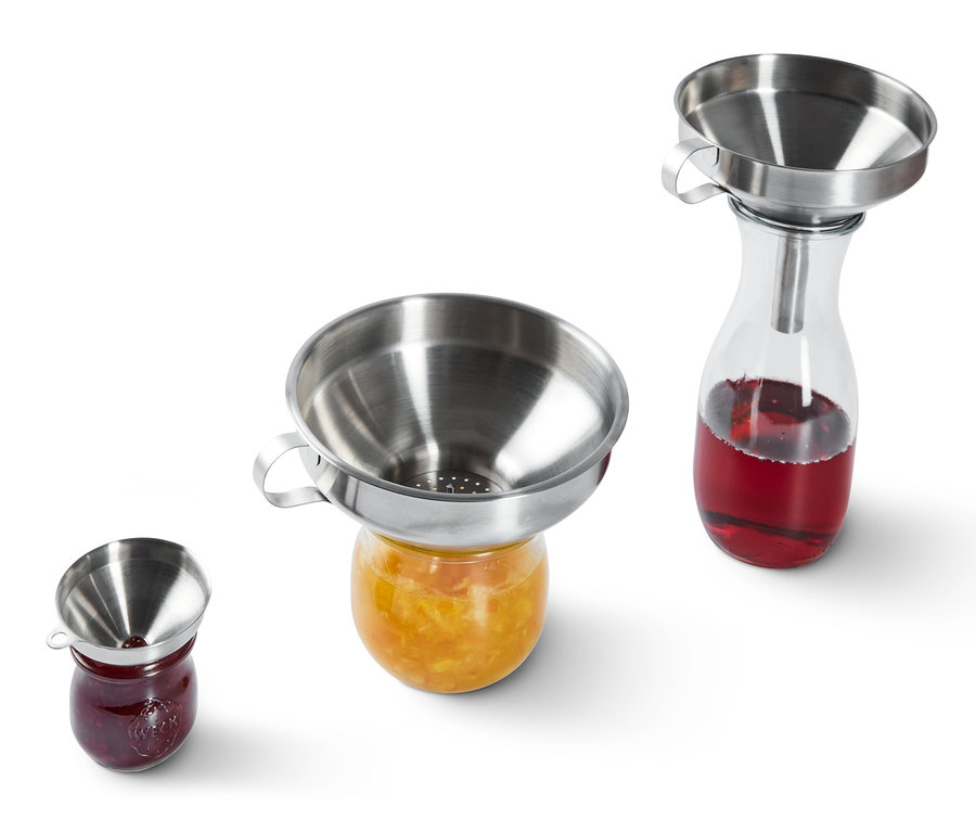 Nerezové trychtýře stojí na sklenicích s džemem.