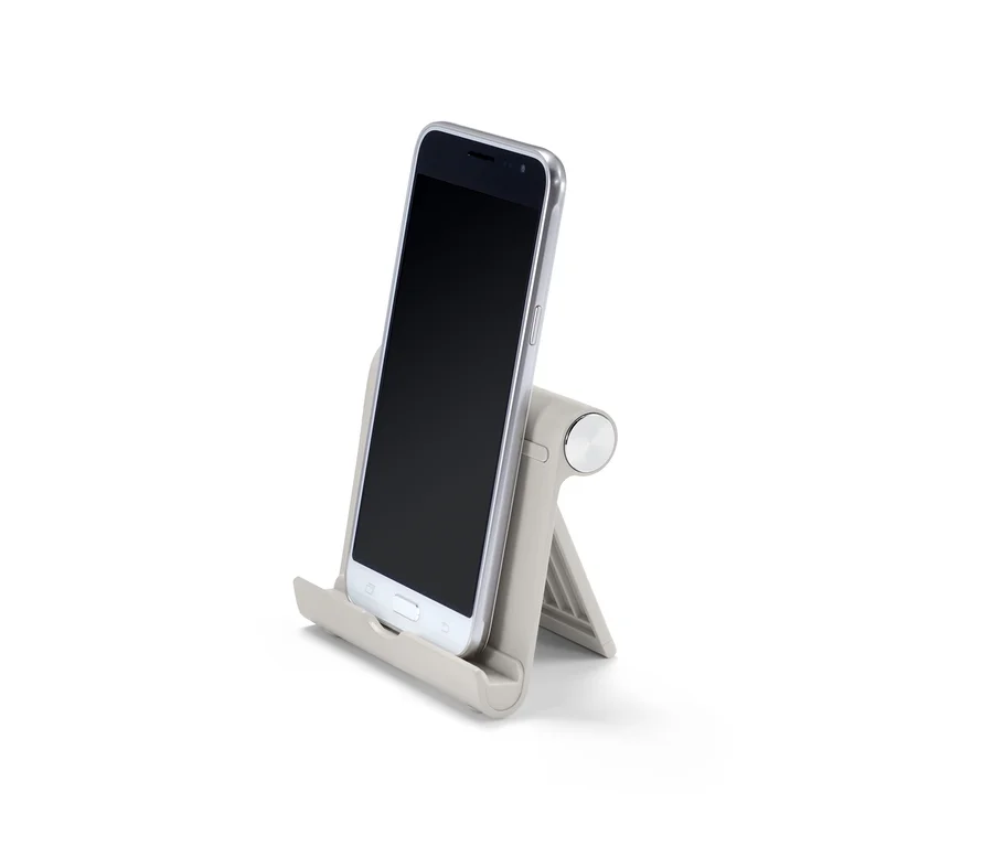 Šedý smartphone je opřený o šedý stojánek na smartphone/tablet.