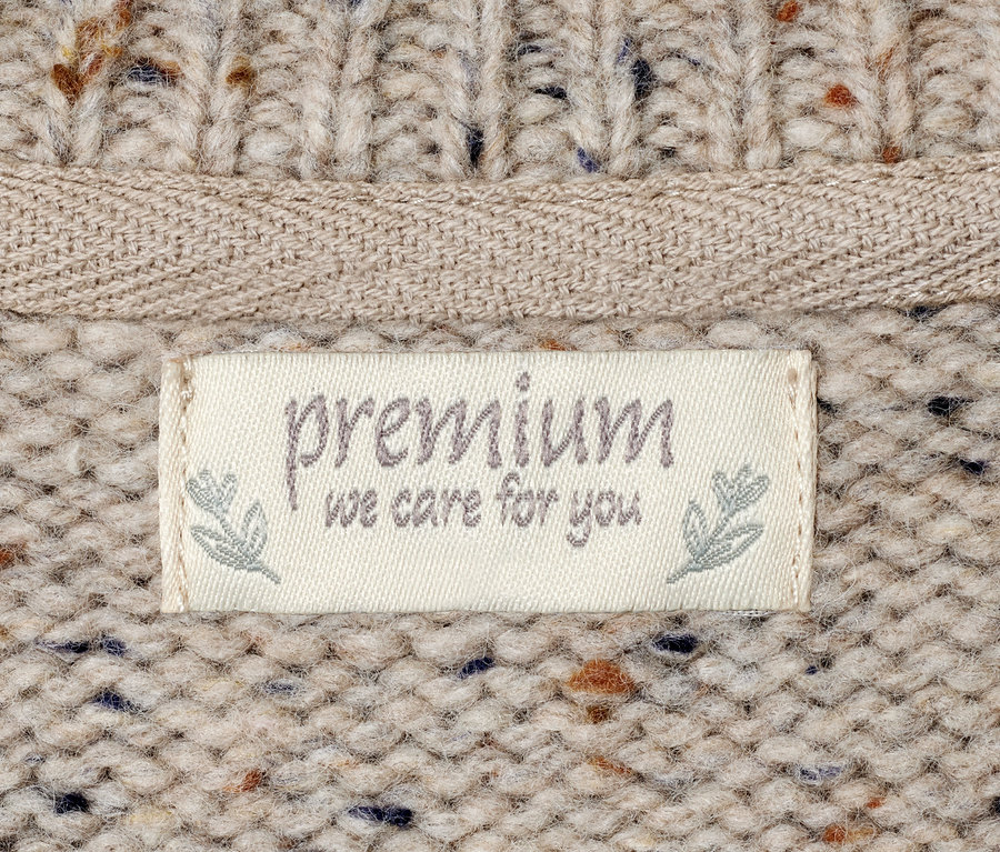 Detail svetru s cedulkou Premium.