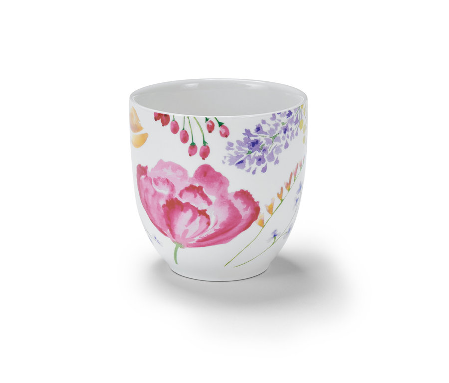 Bílý hrnek s květinovým vzorem.