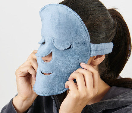 Žena si na obličej nasazuje světle modrou masku na obličej, 2 ks.