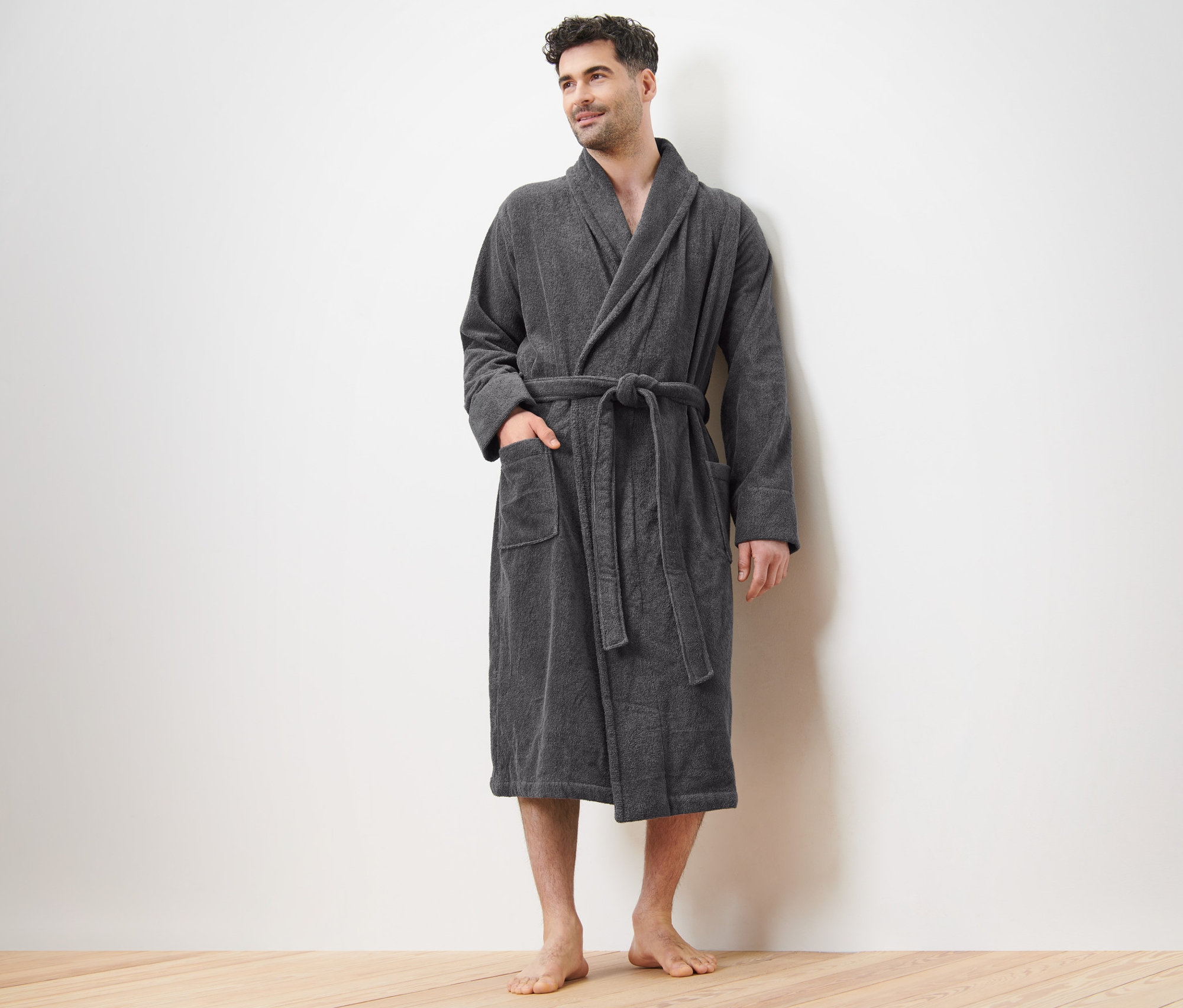 Muž stojí a má na sobě šedý pánský župan.