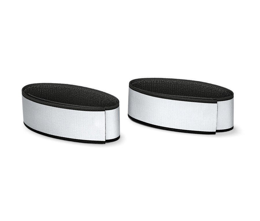 Dva reflexní pásky na kalhoty leží vedle sebe.