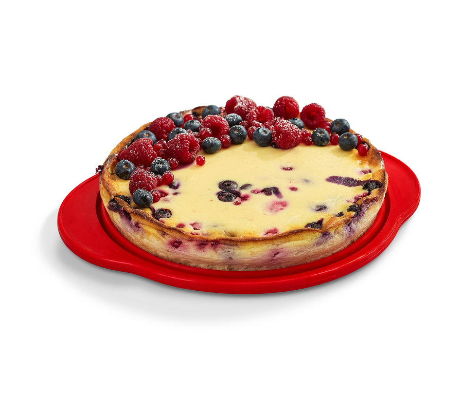 Dort zdobený ovocem na červené rozkládací formě na koláč.