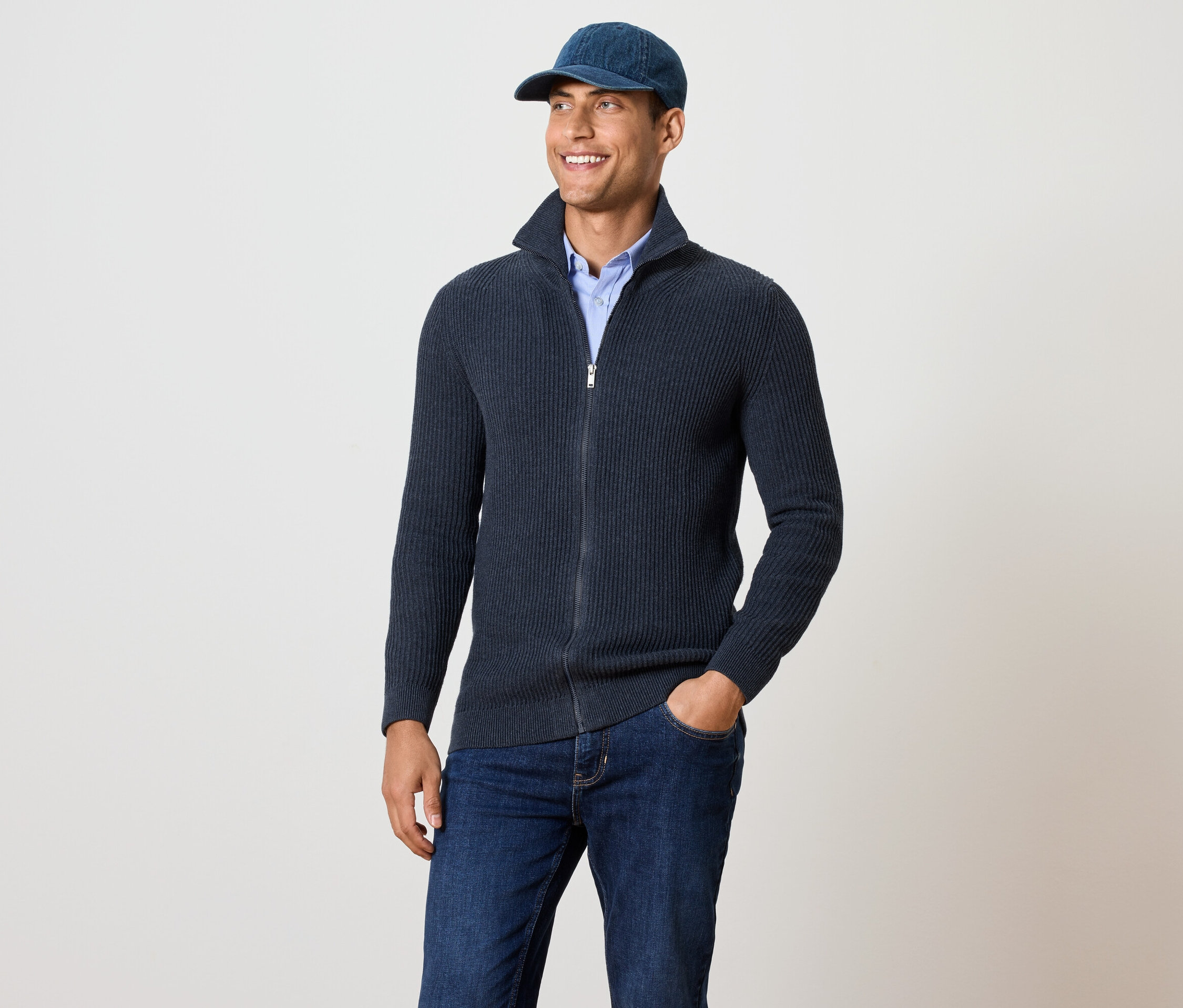 Muž má na sobě pletený svetr, námořnická modrá s melírem.