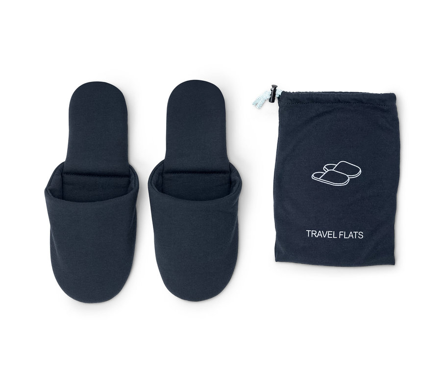 Dvoje modré cestovní pantofle vedle modrého pouzdra.