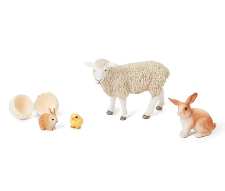 Otevřené vejce vedle sady Schleich® »Velikonoční zvířátka«, která obsahuje jehně, králíka a kuře.