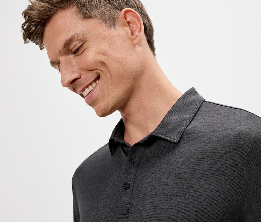 Usmívající se muž v šedém polotričku.