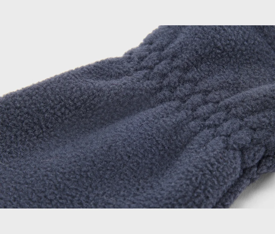 Detail tmavě modrého fleecového materiálu s jemnou texturou a horizontálním prošíváním.