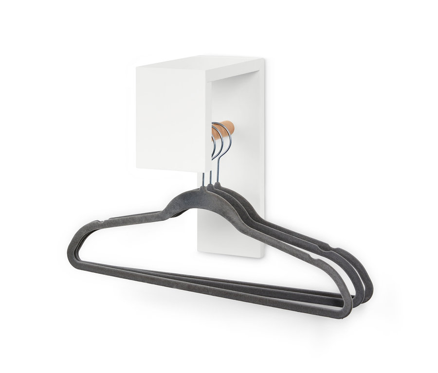 Tři šedá ramínka visí na malém věšáku na šaty.