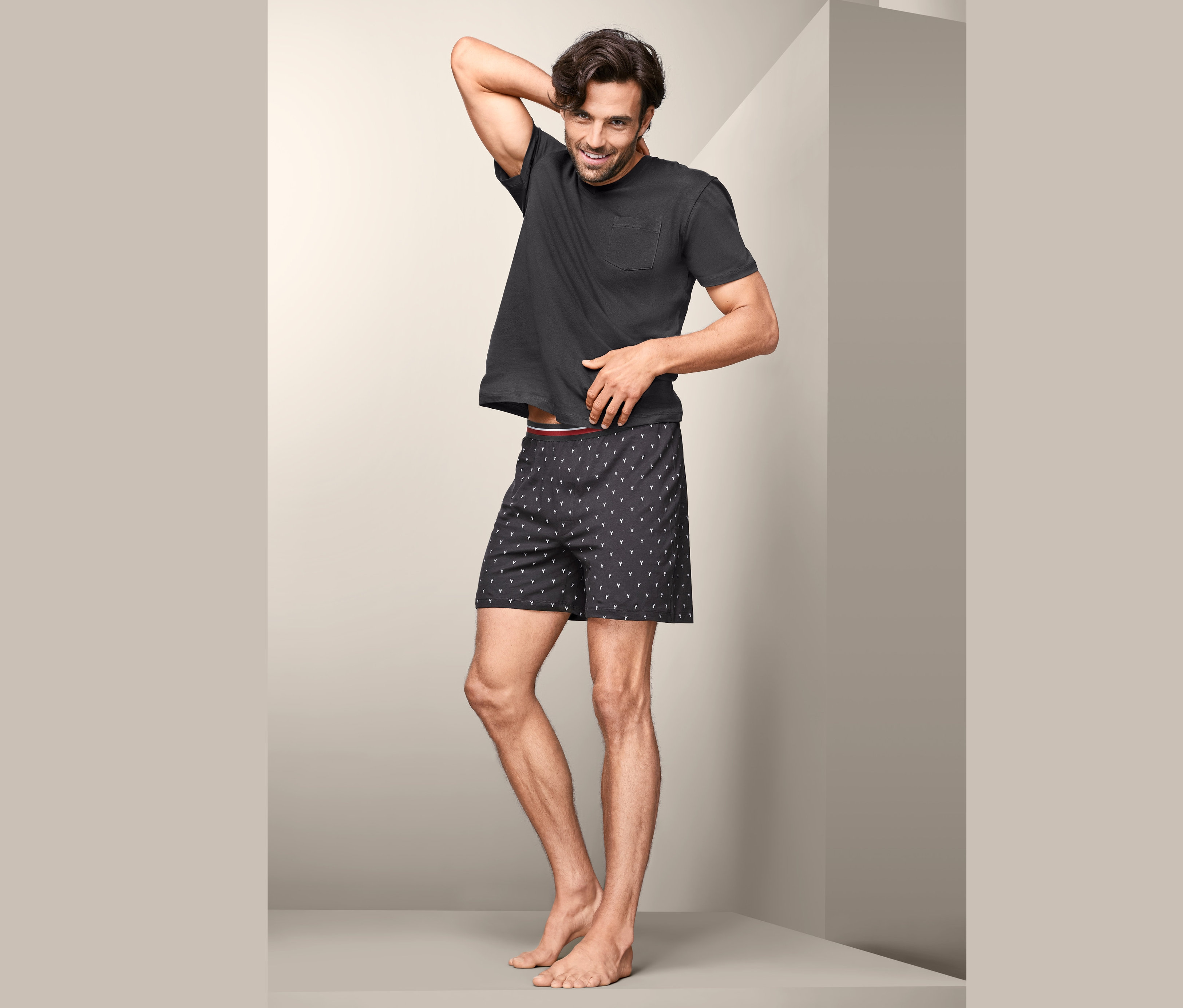Muž pózuje v krátkém pyžamu.