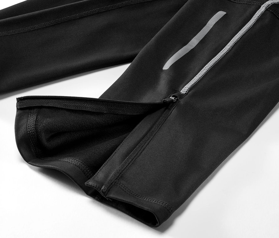 Detailní pohled na černé běžecké termolegíny s rozepnutým zipem na nohavici.