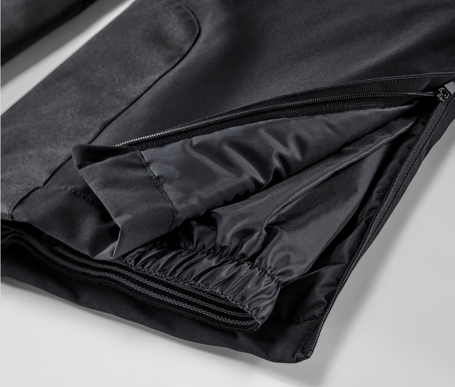 Detail černé lyžařské kalhoty se zipem.