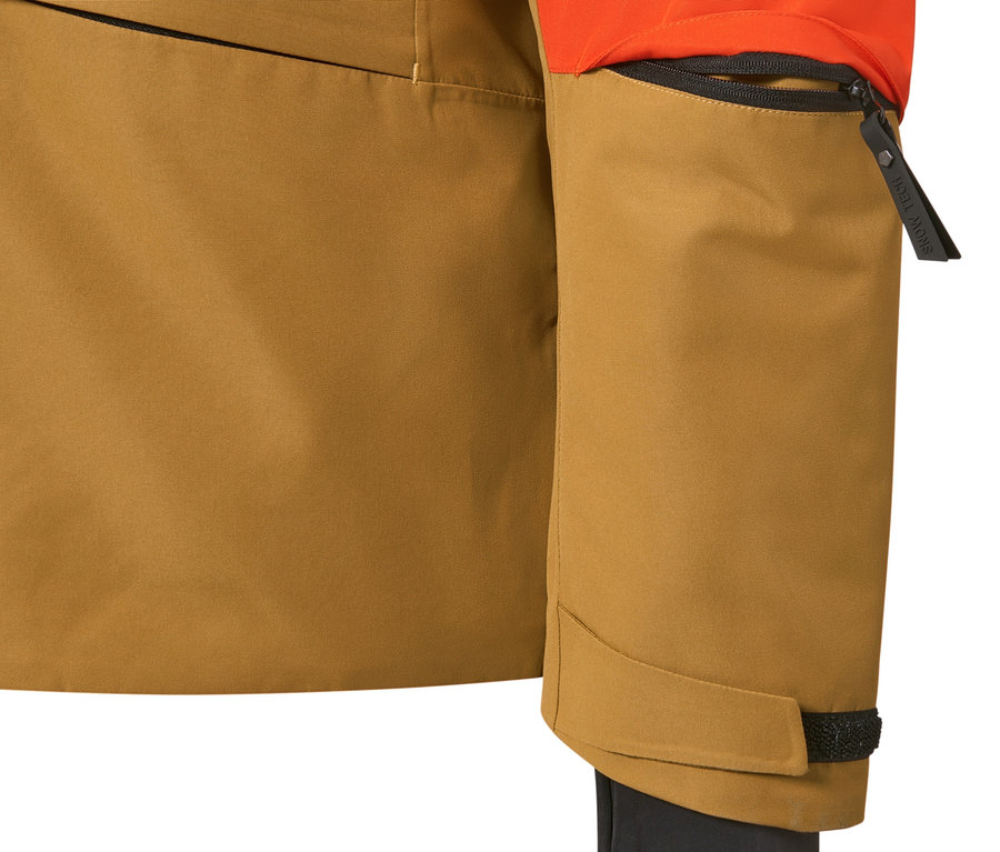 Detail oranžovo-hnědé lyžařské bundy.