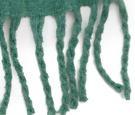 Detail zelené tkané šály s třásněmi.