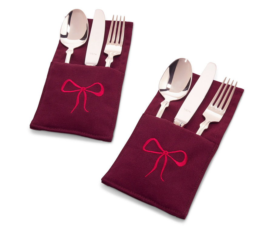 Dvě sady příborů ve vínových látkových obalech s výšivkou červené mašle.