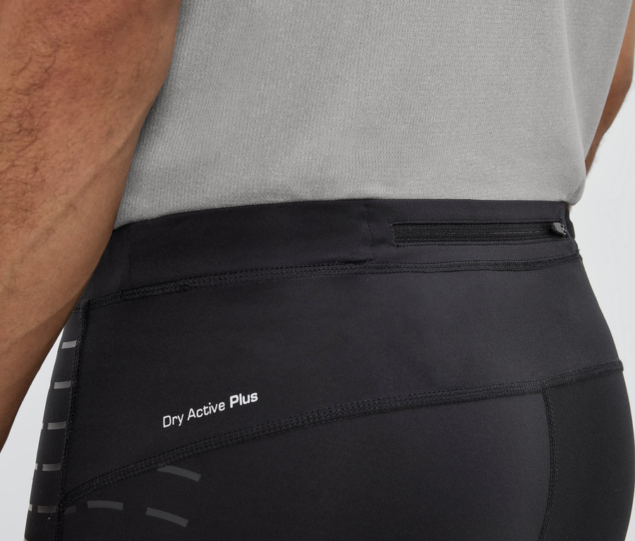 Muž má na sobě černé legíny s nápisem Dry Active Plus a kapsou na zip v pase.