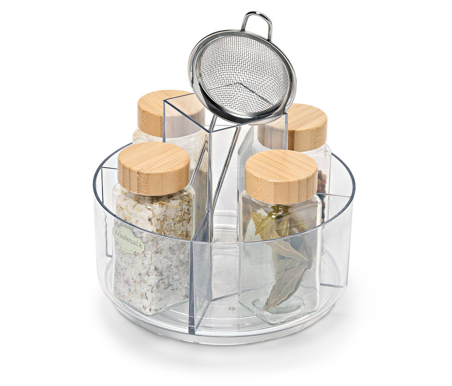 Pět skleněných dóz s dřevěnými víčky v otočném stojanu. Jedna dóza obsahuje bylinkovou sůl, na stojanu je nerezové sítko.