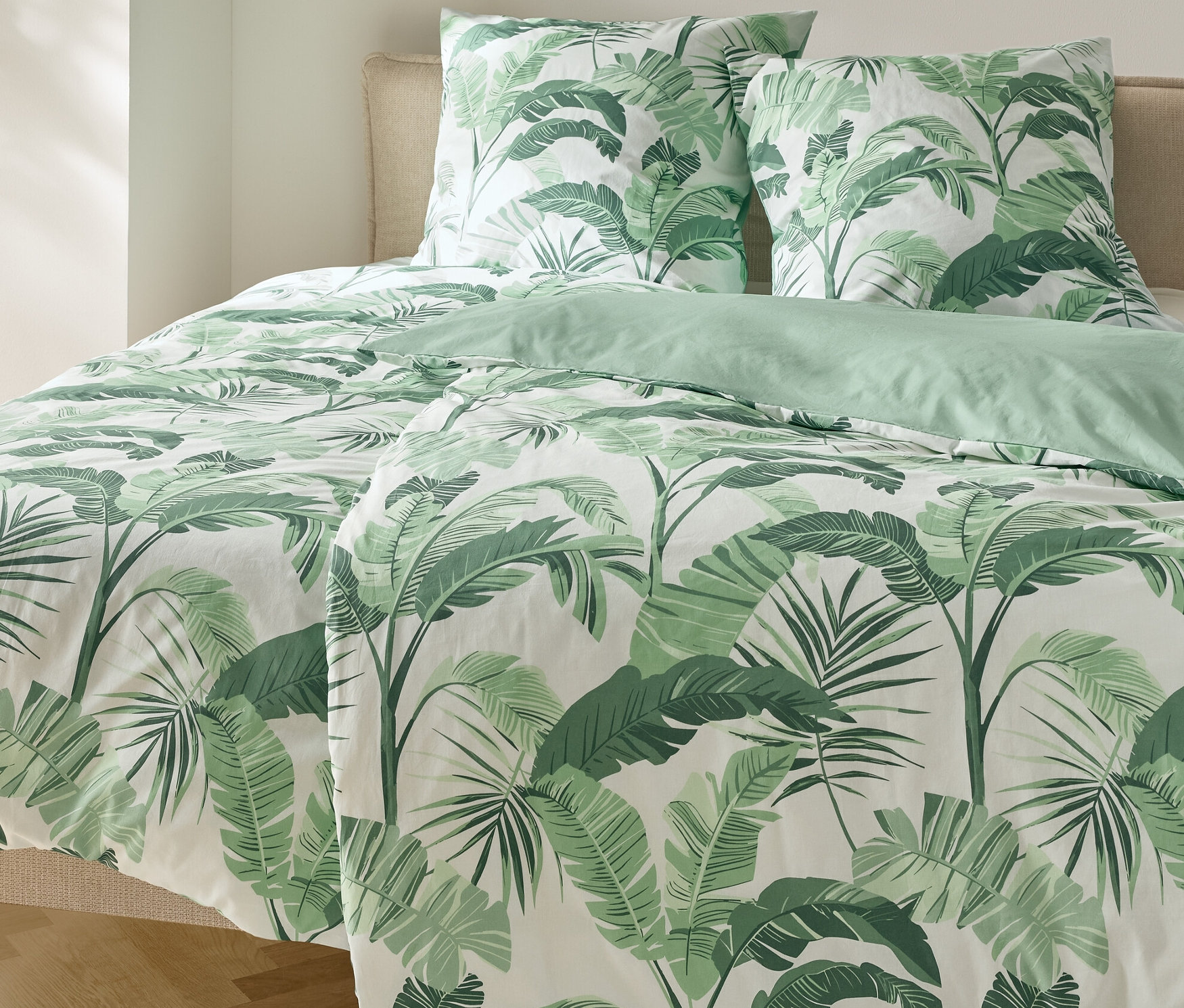 Postel s povlečením renforcé s motivem palem a dvěma polštáři.