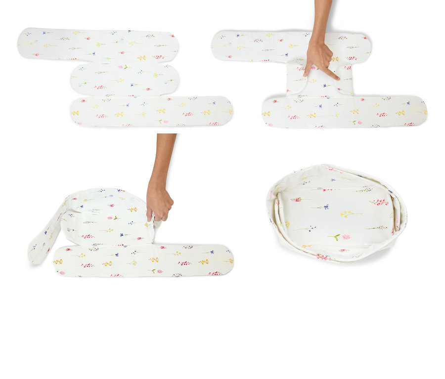 Ruce skládají bílé dětské lehátko s květinovým vzorem.