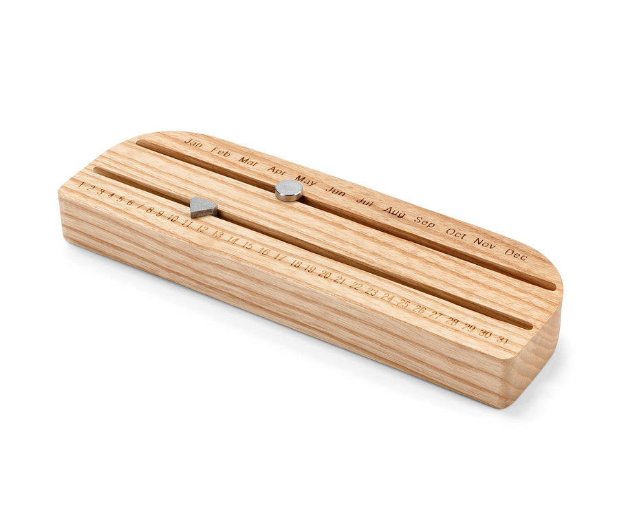 Dřevěný věčný kalendář s posuvnými magnety ukazujícími den a měsíc.