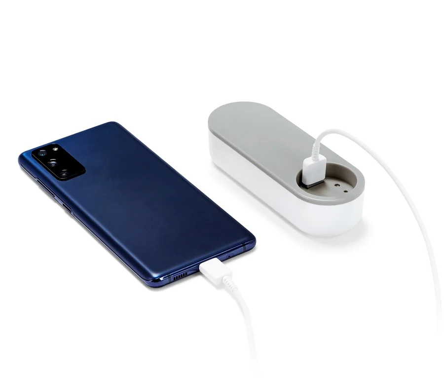 Tmavě modrý smartphone se nabíjí pomocí powerbanky.