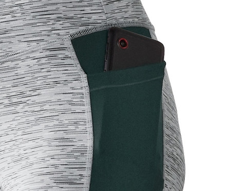 Detail sportovních legín s barevnými bloky a kapsou, ve které je telefon.