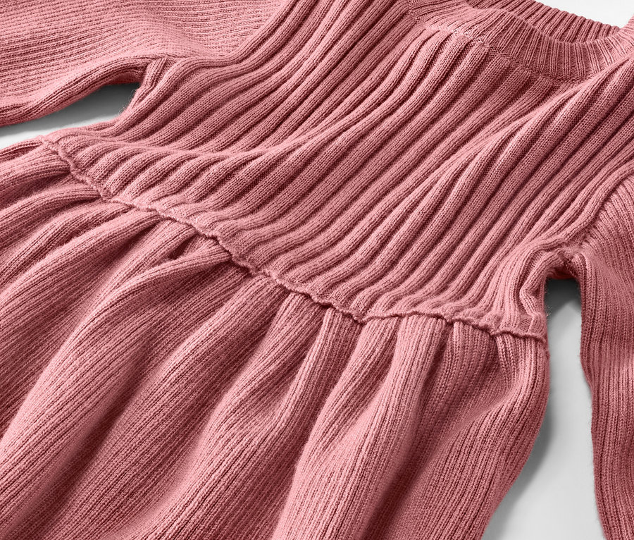 Detail dívčích pletených šatů z vlny merino.