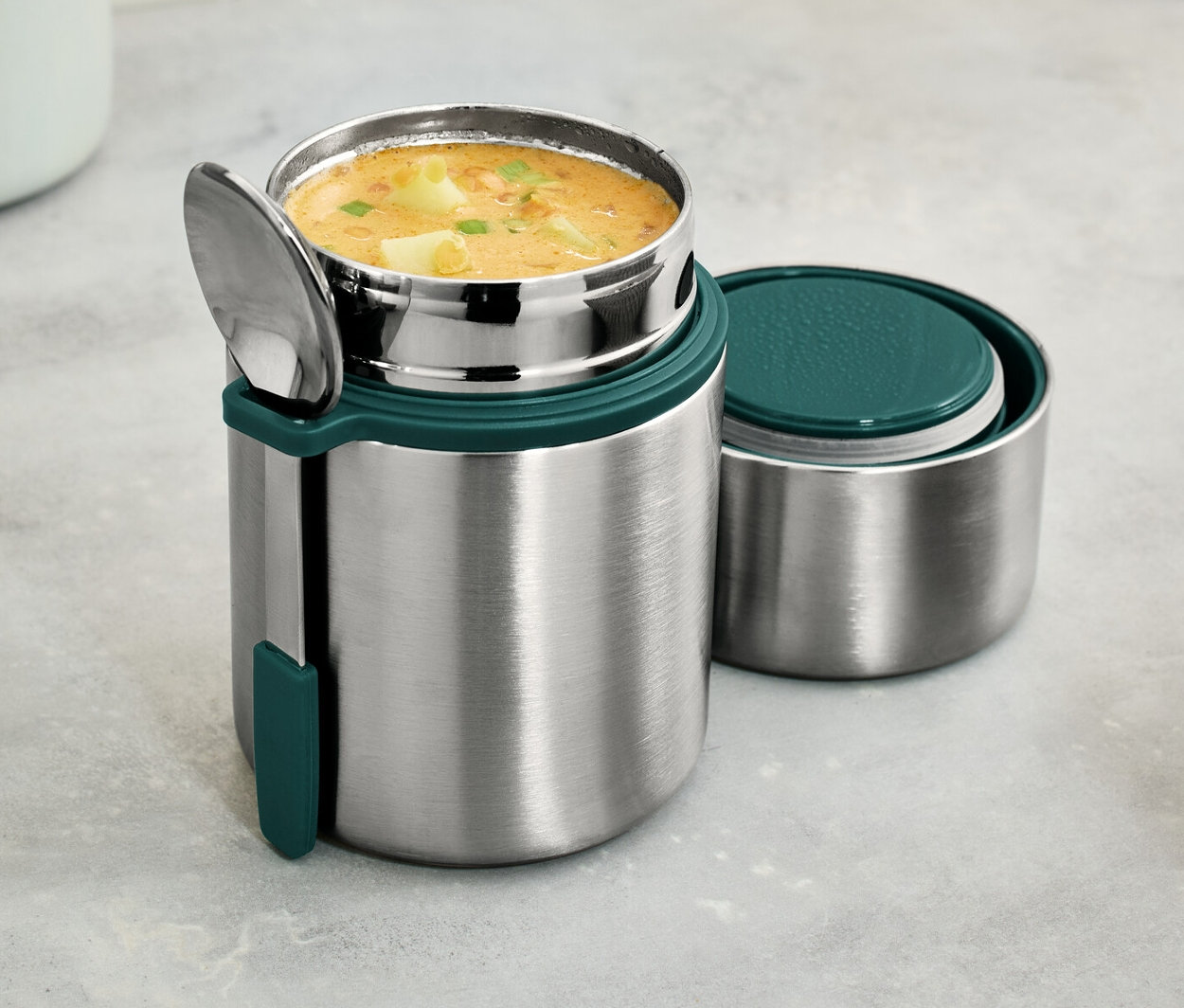 Nerezová termonádoba na cesty s polévkou a lžící.