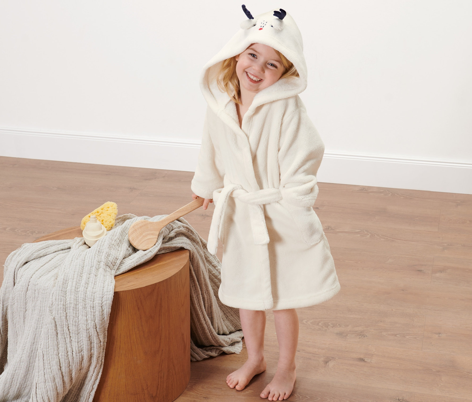 Dívka v dětském županu s kapucí.