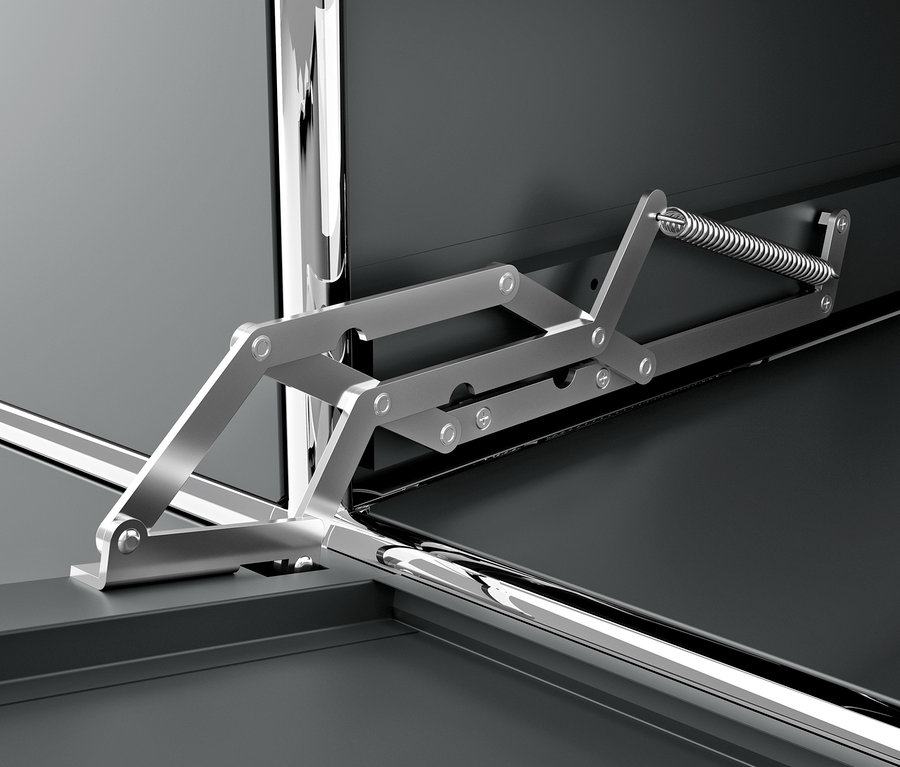 Detail šedé kovové skříňky CN3 s výklopnými dvířky a mechanismem.