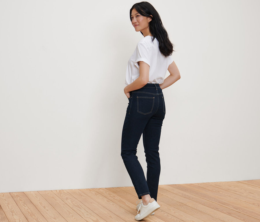 Žena pózuje v džínách slim-fit »Emma« a bílém tričku.