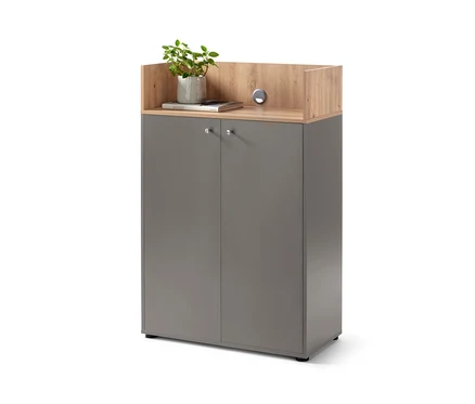 Vysoká skříňka se 2 dvířky šedé barvy s dřevěnou deskou, na které je květina v květináči a kniha.