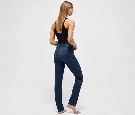 Žena stojí zády a má na sobě tmavě modré džíny Angels »Cici« slim fit a černé tílko.