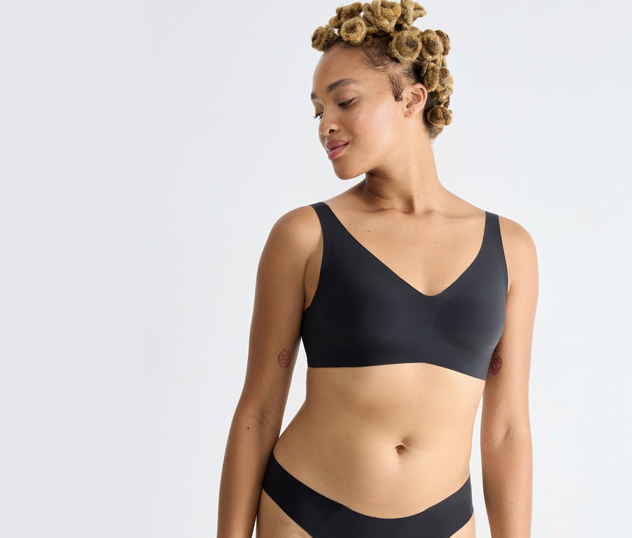 Žena má na sobě černou podprsenku sloggi ZERO Feel 2.0 Soft Bra.