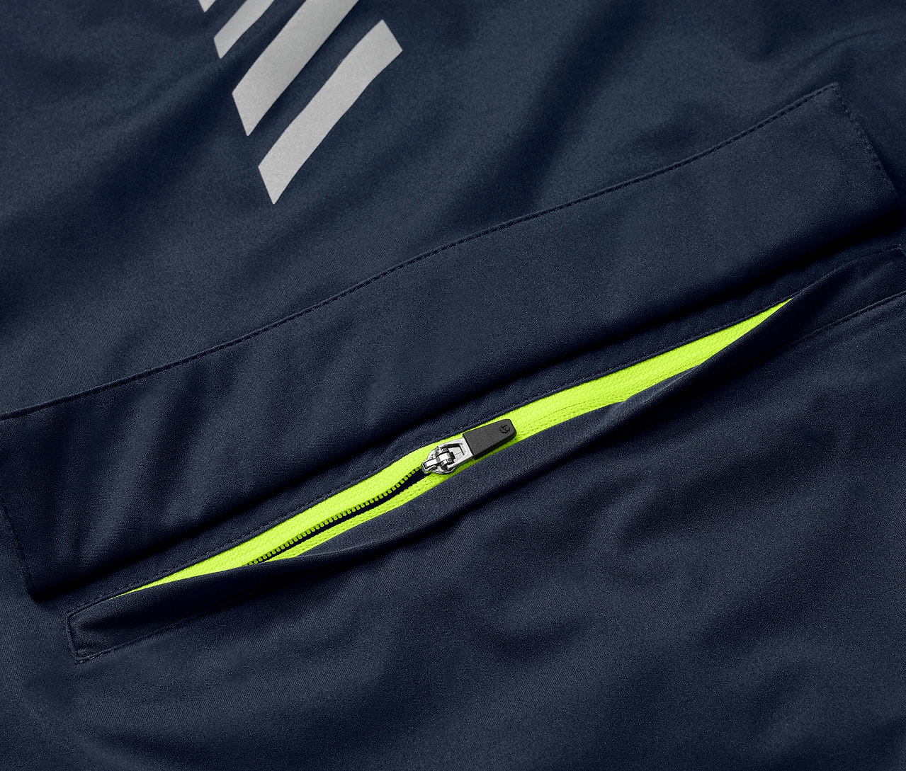 Detail modré cyklistické větrovky Rad-Regenjacke s neonově zeleným zipem na kapse a reflexními prvky.