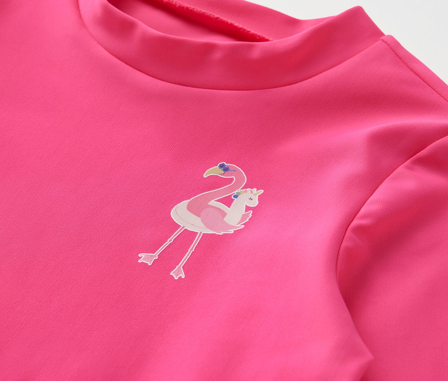 Detail růžového dětského setu s UV faktorem 80 s potiskem plameňáka.