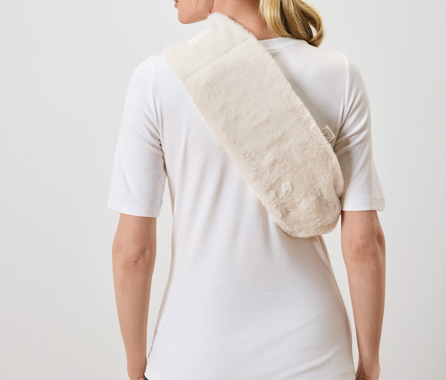 Žena zády k fotoaparátu má přes rameno přehozený chlupatý krémový šál.