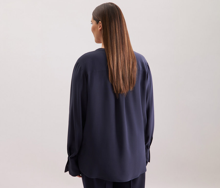 Žena zezadu v tmavě modré tunice z viskózy Seidensticker.