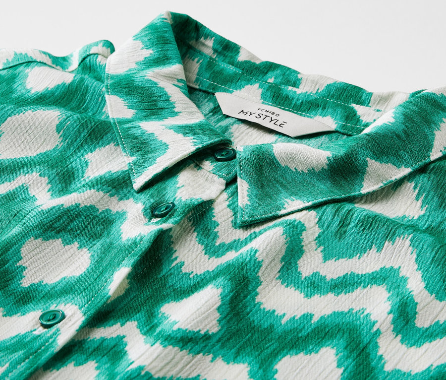 Detail košilových šatů s potiskem.