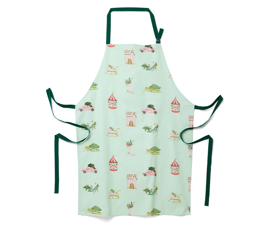 Světle zelená zástěra s vánočním motivem domečků, aut, saní a kolotočů.