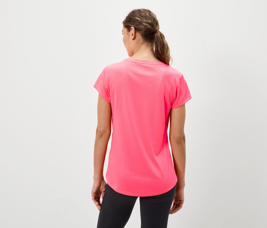 Žena zády k fotoaparátu má na sobě růžové tričko a černé legíny.