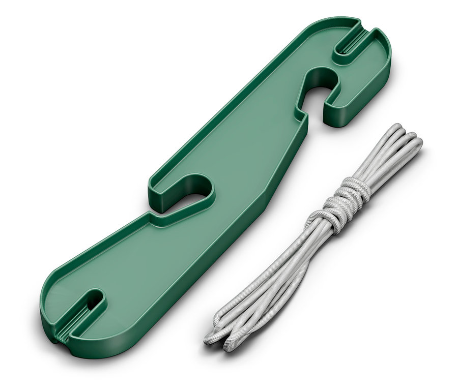 Zelený plastový organizér kabelů leží vedle smotané bílé šňůry.