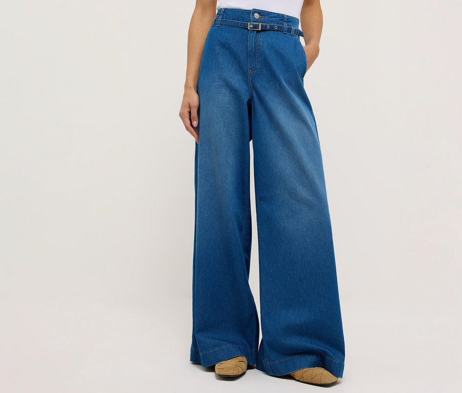 Osoba má na sobě džíny Angels Denim »Liva« Sleek Wide Leg a hnědé boty na bílém pozadí.