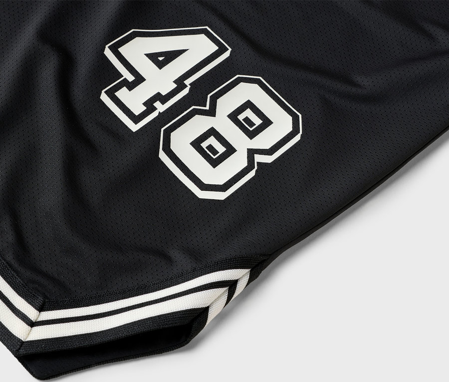 Detailní záběr na černé basketbalové šortky s číslem 48 v bílé barvě.