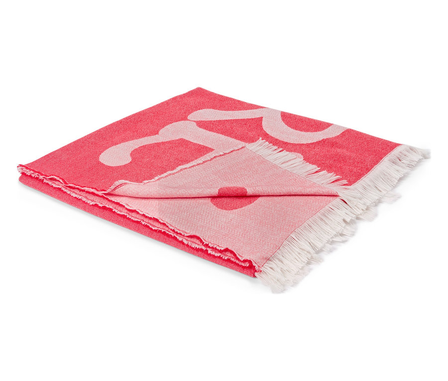 Složená červená deka s bílým vzorem a třásněmi na koncích.