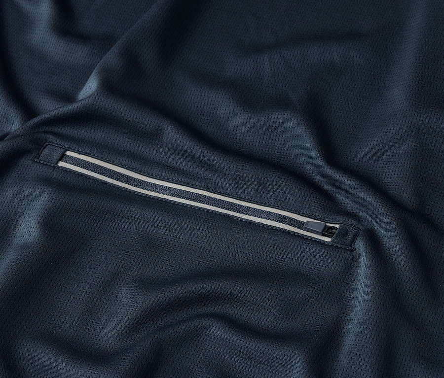 Detailní záběr na tmavě modrou látku s kapsou na zip.