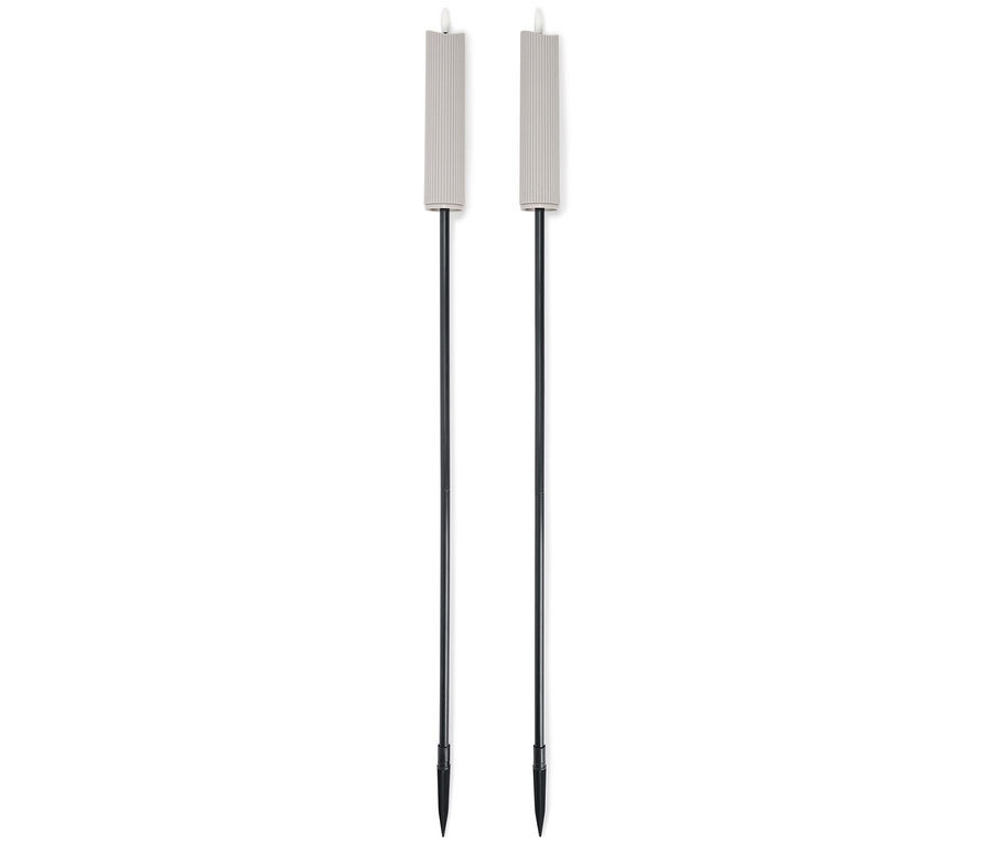 Dva béžové zahradní pochodně s černými tyčemi stojí vedle sebe na bílém pozadí.